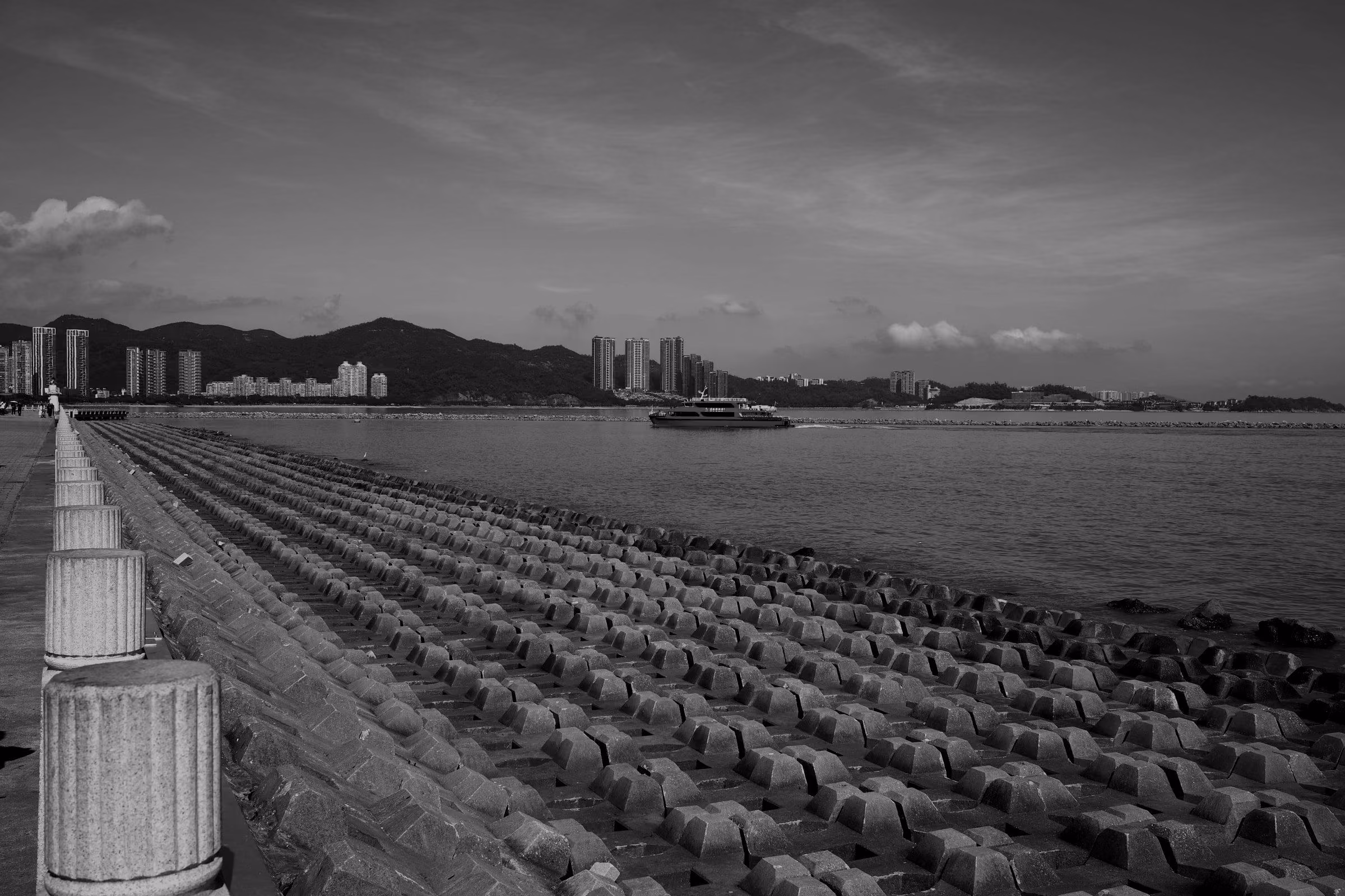 The Zhuhai waterfront on a sunny day, with a ferry and the city skyline.