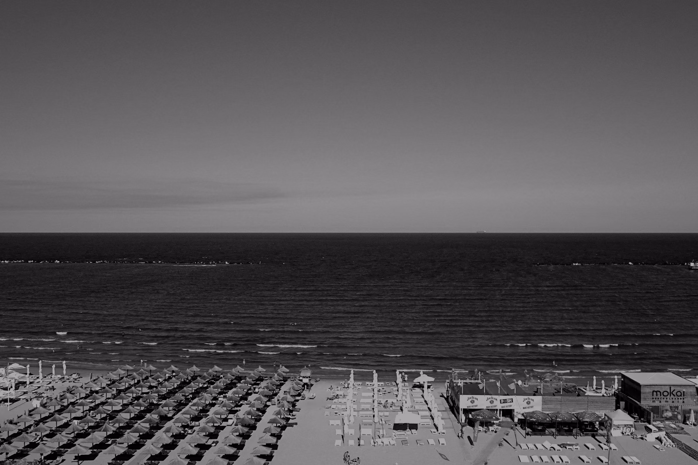 Beach umbrellas along the sand at Mamaia, with the Black Sea beyond.