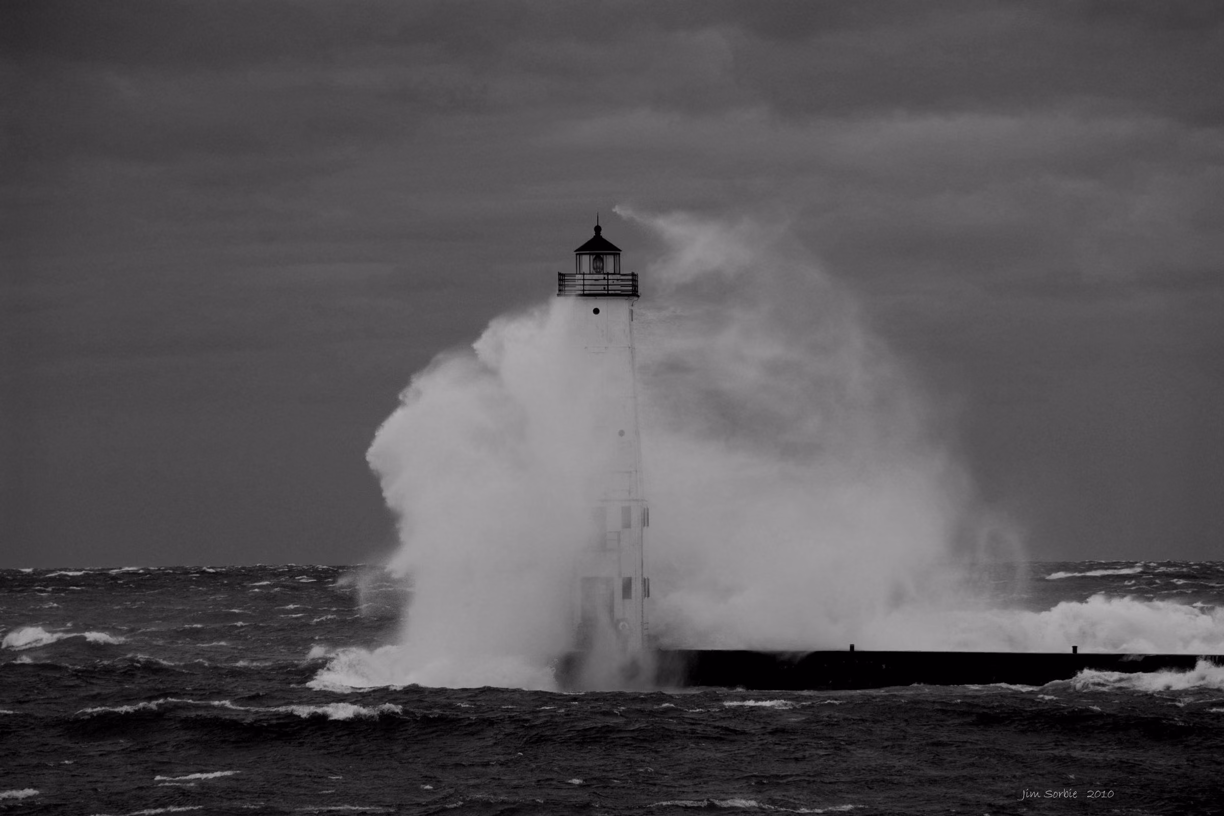 A lighthouse stands on the shore near Frankfort, Michigan, USA, overlooking Lake Michigan.