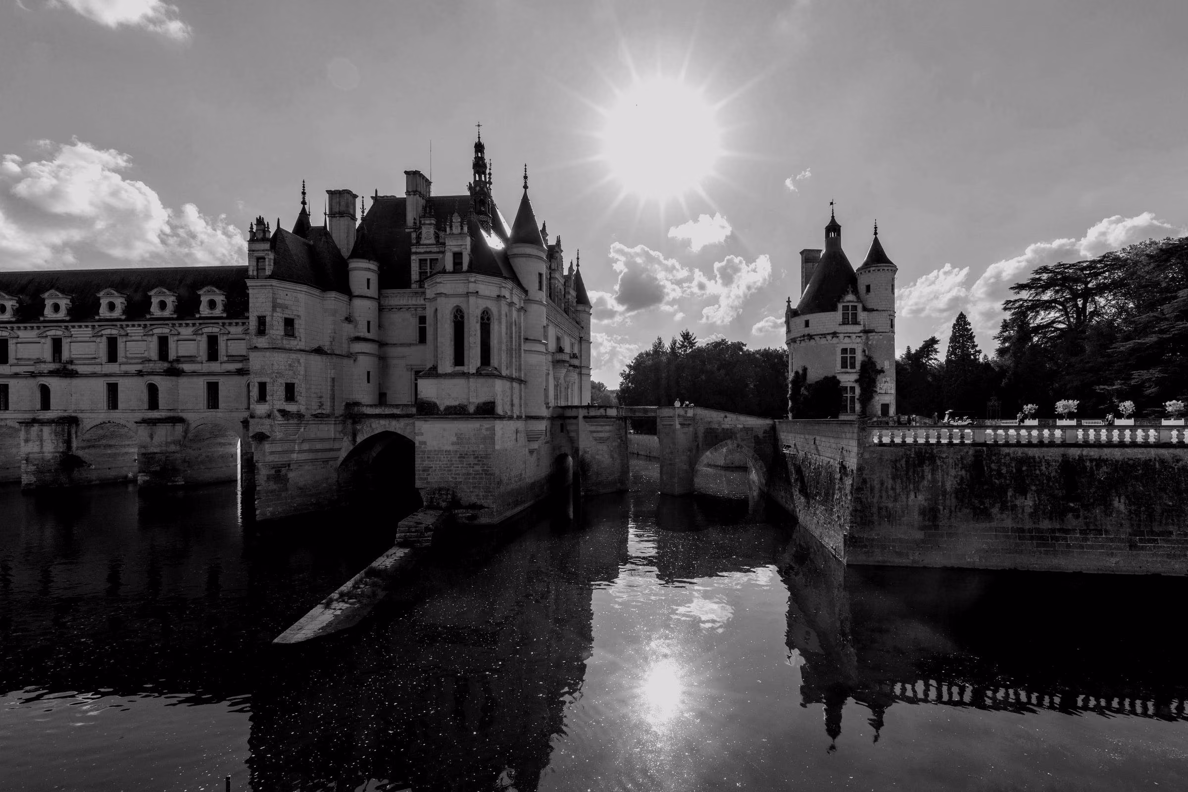 The Château de Chenonceau spans across the river Cher with reflections on the water.