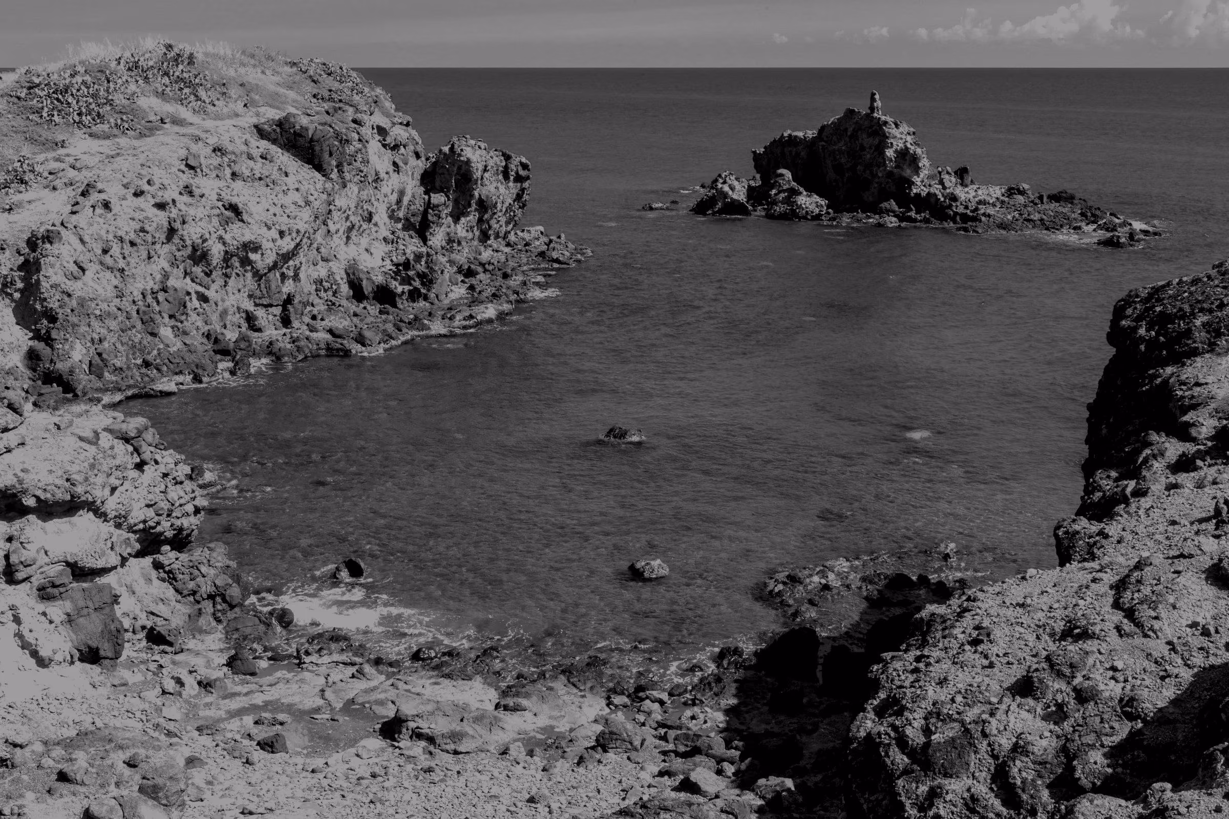 A rocky coastline with turquoise water and cliffs.