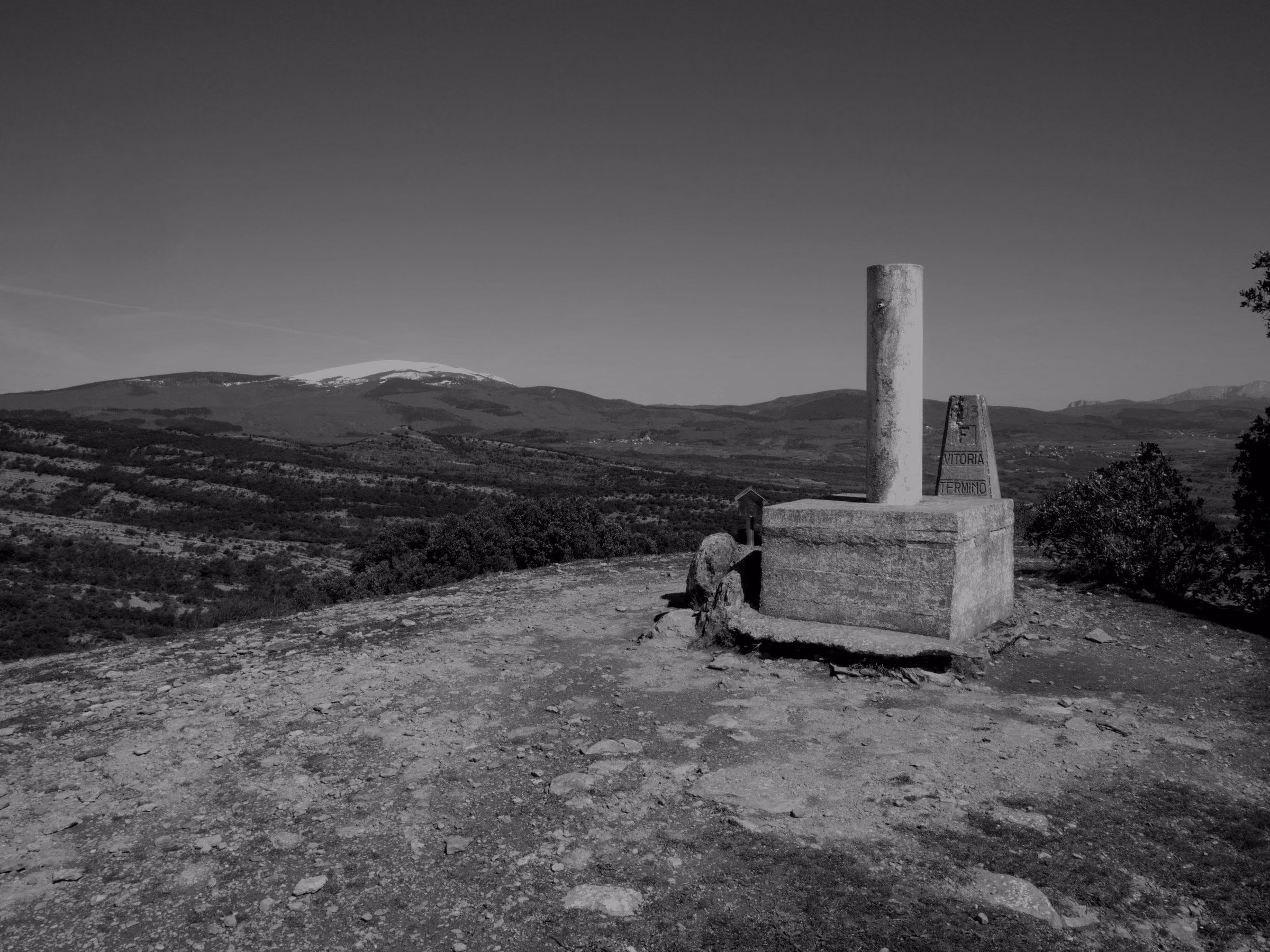 A wide view of the mountain landscape and snowy peaks from a stone monument in Vitoria-Gasteiz.